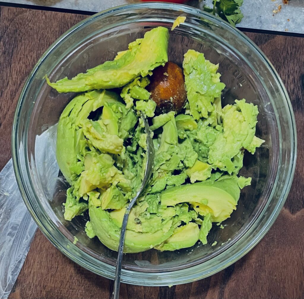 Avocados and 1 pit in a clear bowl