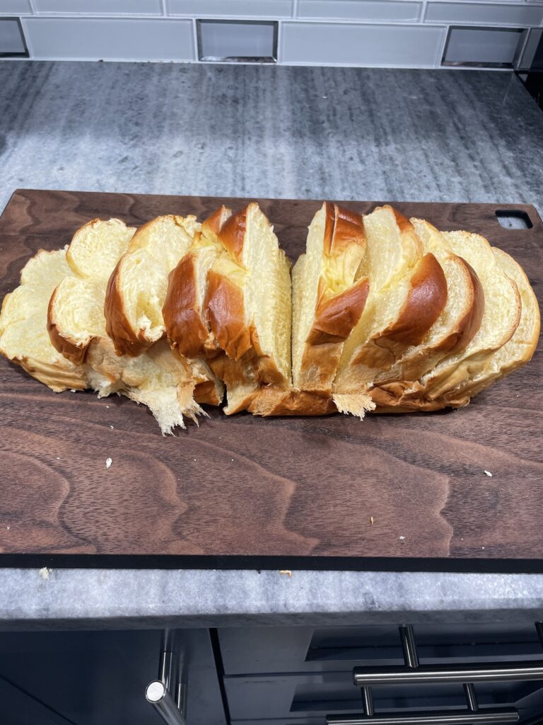 Sliced Brioch Bread on brown cutting board.